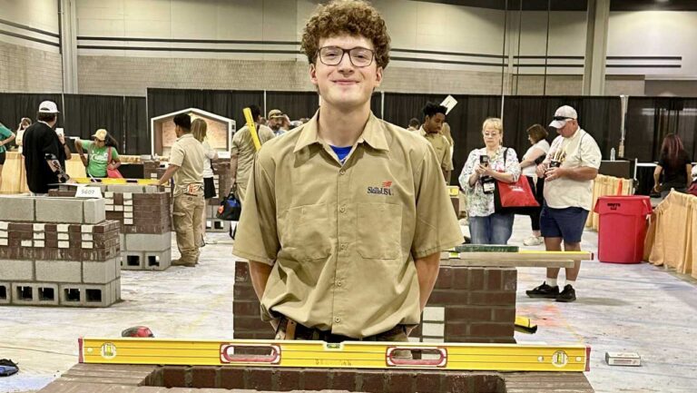 Sam Berryman standing behind his state conference masonry project.