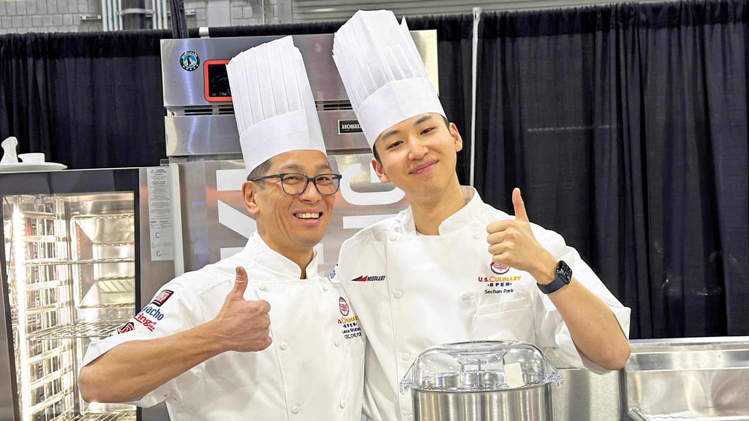 Chef Lance Nitahara and Sechan in a kitchen giving the thumbs up.