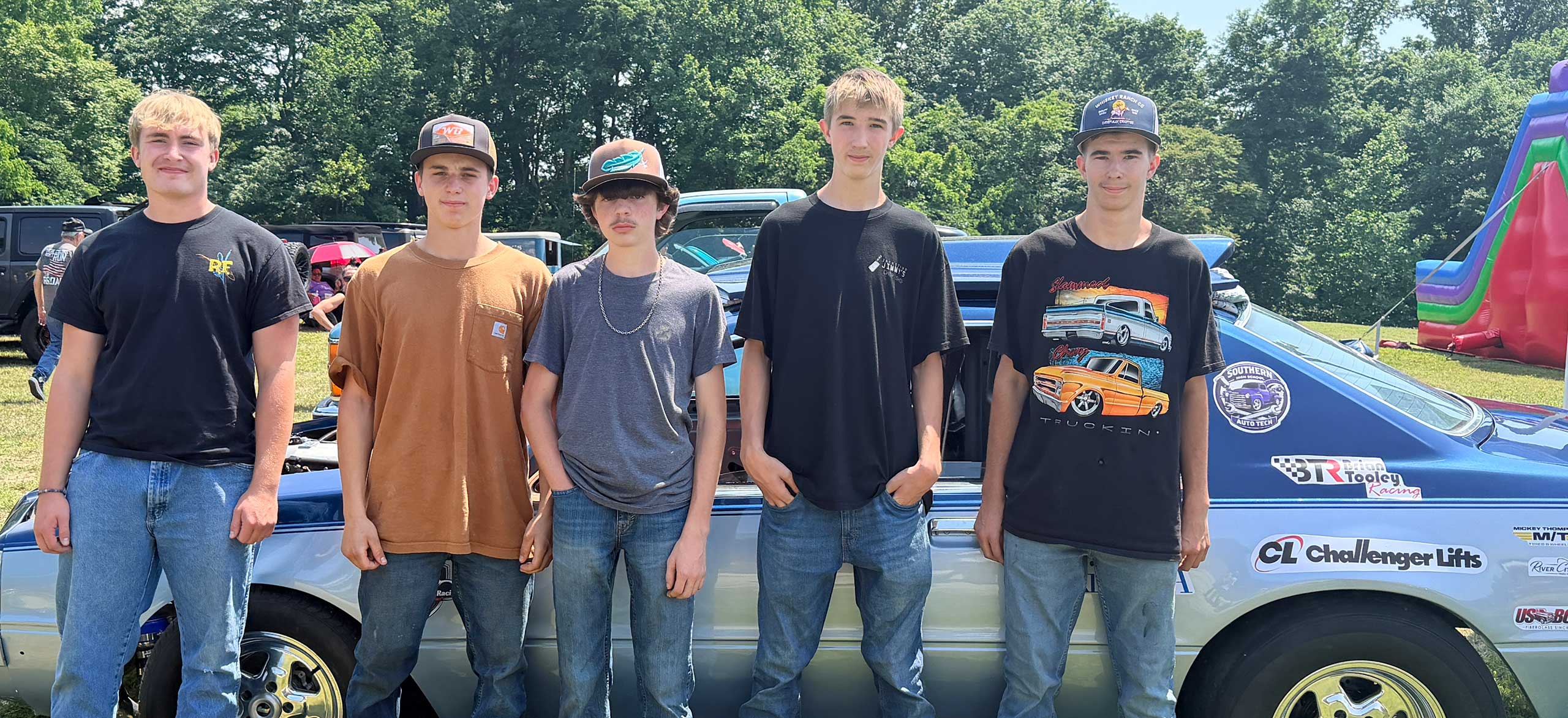 Students pose with a muscle car